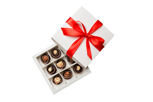 Chocolate candy in a box with a colored bow. Gift box with Chocolates isolated on white top view.