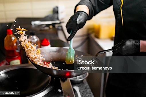 istock Chef cooking stir fry rice and chicken in wok pan at restaurant kitchen. 1646146393