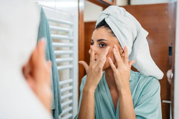 istock Young Woman Looking At Herself In The Bathroom Mirror 1646167186