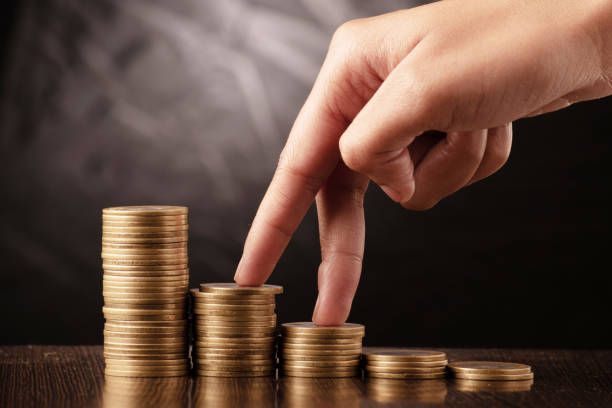 istock Finger stepping towards coin stack, making money and profit concept 1646181793