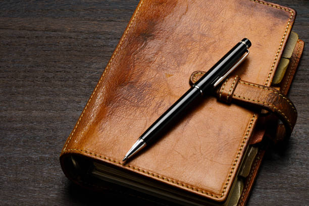 istock Ring bound planner and pen on wooden table 1646203819