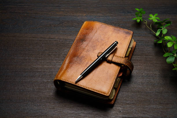 istock Ring bound planner and pen on wooden table 1646203828