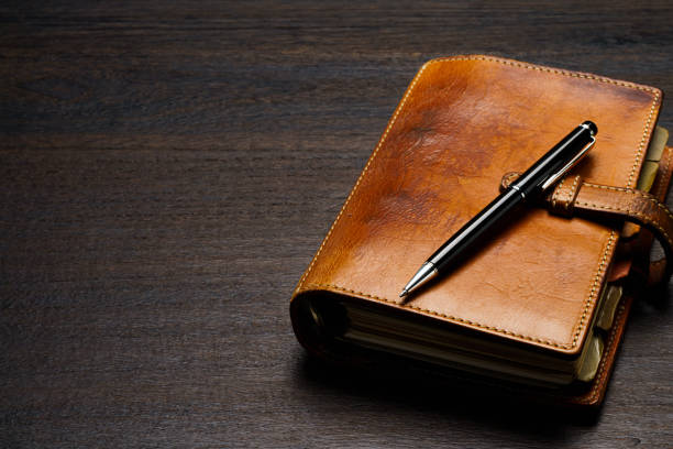 istock Ring bound planner and pen on wooden table 1646203839