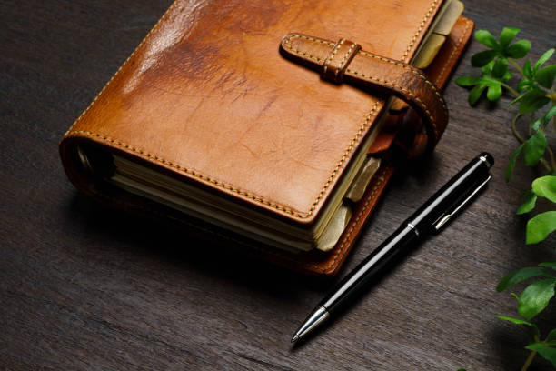 istock Ring bound planner and pen on wooden table 1646204008