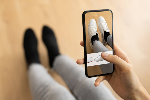 frau versucht virtuelle sneakers im online-shop - augmented-reality stock-fotos und bilder