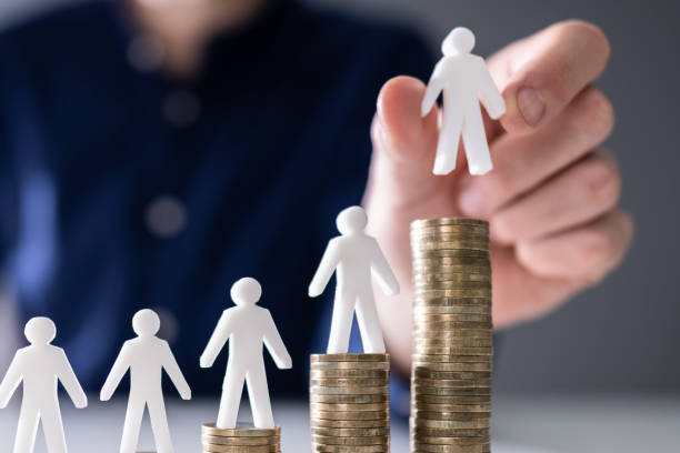 istock Human Hand Placing Human Figure On Increasing Stacked Coins 1646205496