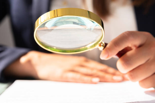 istock Businesswoman Looking At Contract Form Through Magnifying Glass 1646205500