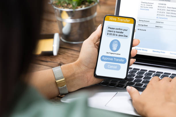 istock Woman Using Mobile Phone App To Authenthificate Bank Transfer 1646205511