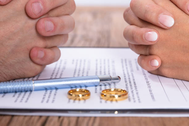 istock Couple's Hand With Divorce Agreement And Wedding Rings 1646205514