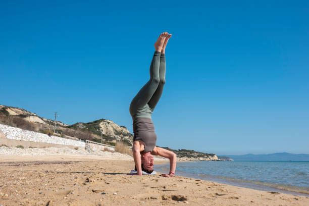 istock Attractive middle-aged woman practicing yoga on a beautiful beach 1646235283