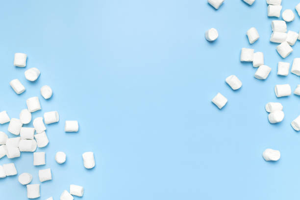 istock White sweet marshmallows on blue background flat lay top view copy space. Winter or autumn food concept, New Year's or Christmas sweetness, candy, dessert. Marshmellow texture. Minimalistic style 1646236356