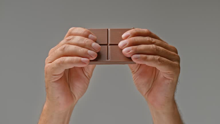 SLO MO LD Hands breaking a chocolate bar in half