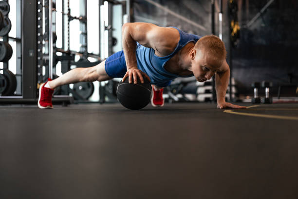 istock Fit man doing push ups on medicine ball at the gym. 1646242364
