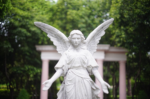 an angel statue in the middle of a park