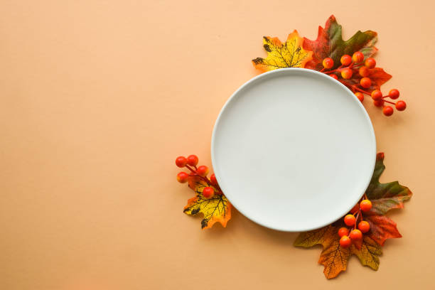 istock Autumn table setting. White plate, golden cutlery and fall decorations. 1646253971
