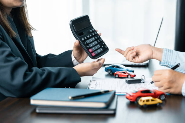 アジアの女性の接写 自動車販売業者またはセールスマネージャーは、車を売ることを申し出、自動車契約と保険に署名する条件を説明し、読みます。 - car loan ストックフォトと画像