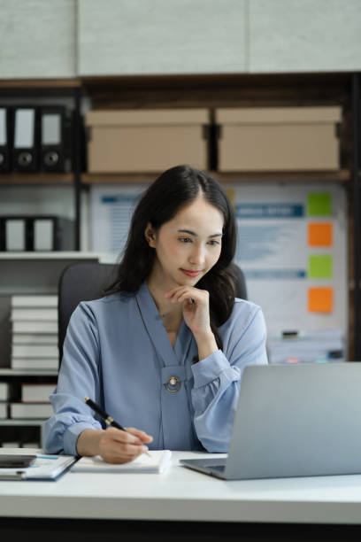 istock Business women hand working with tablet and laptop computer with documents on office desk in modern office. 1646260894