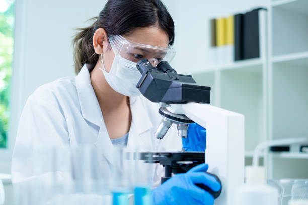 istock Medical Research Laboratory. Female Scientist Using Microscope to analyze substance or liquid, virus. Professionals Working in Advanced Scientific Lab doing Medicine, Vaccine, Biotechnology test 1646281708
