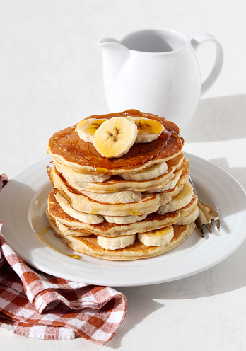 Pile of banana pancakes with honey on plate