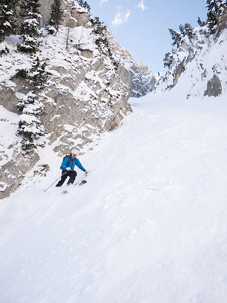 Skier in steep chute stock photo