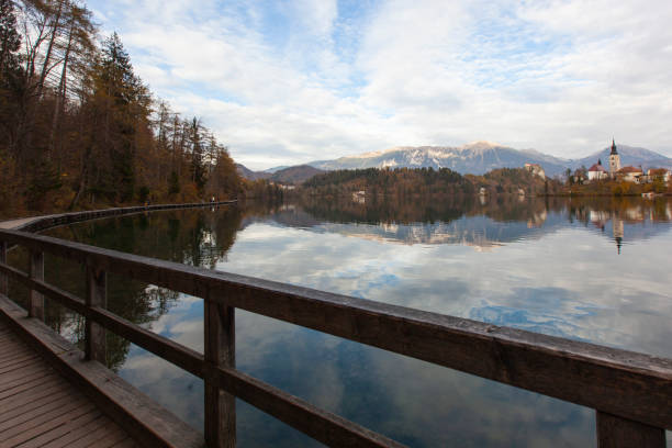 bled lake reflections and julian alps in the spring season photo, radovljica bled, slovenia - julian alps mountain lake reflection imagens e fotografias de stock