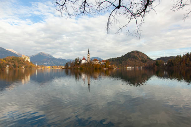 bled lake reflections and julian alps in the spring season photo, radovljica bled, slovenia - julian alps mountain lake reflection imagens e fotografias de stock