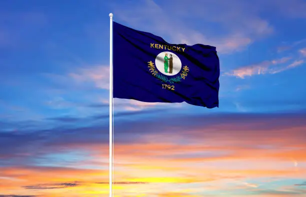 Photo of Kentucky flag on flagpoles and blue sky