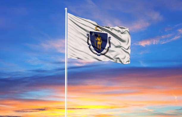 drapeau du massachusetts sur les mâts et ciel bleu - massachusetts flag state insignia photos et images de collection