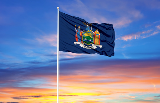 flag of New York on flagpoles and blue sky. Patriotic concept about state.