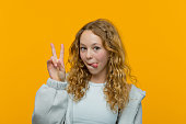 Portrait of cute teenage girl showing v sign