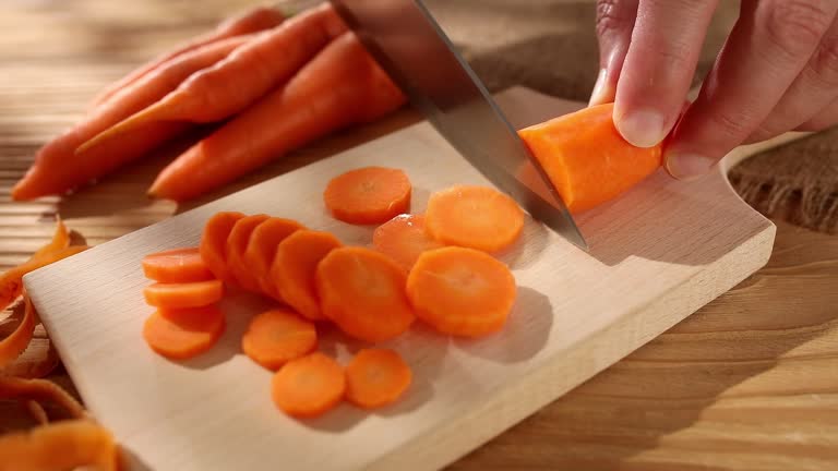 preparing vegetables. cutting carrots on a cutting board. smooth camera zoom.