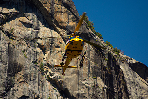 A search and rescue helicopter, Tail Number N393P, takes off from a meadow in Yosemite Valley after receiving a patient from EMS and Park Rangers.
