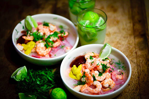 Two bowls of shrimp ceviche with wedges of lime stock photo