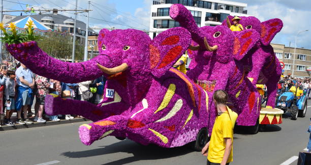 Noordwijk, Keukenhof, The Netherlands - April 20, 2013: People saw a big monkey eats bananas flower car who participated at the annual Flower Parade 2013 with theme Bon Appétit!. This parade travelled around 40 kilometers route along the main roads from Noordwijk to Haarlem.The Parade comprised of 20 large floats and more than 30 decorated luxury cars with flowers, and interspersed with a lot of musical bands.This year Flower Parade 2014 will be held on Saturday May 3rd with theme Energy.