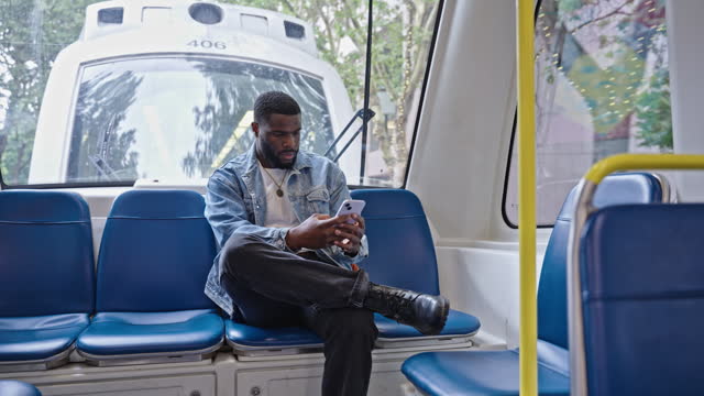 Man looking at his phone while riding on a streetcar