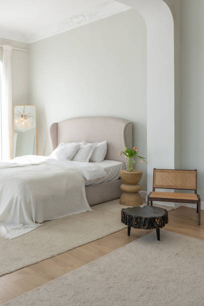 istock a gentle cozy bright apartment with huge panoramic windows with sunlight. bedroom in soft beige tones with a fireplace and a comfortable stylish upholstered armchair and bed 1646358933