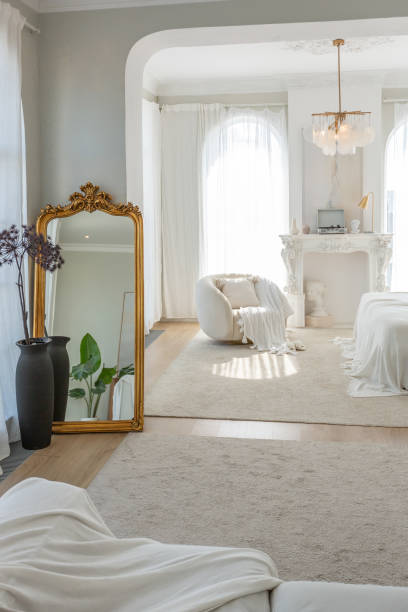 istock cozy bright apartment with huge panoramic windows with sunlight. bedroom in white and beige tones with fireplace and soft armchair. stylish living room with log coffee table and large white sofa 1646360035