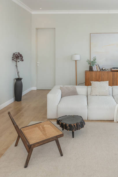 istock cozy bright apartment with huge panoramic windows with sunlight. bedroom in white and beige tones with fireplace and soft armchair. stylish living room with log coffee table and large white sofa 1646360628