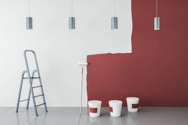 istock Modern interior with red paint on white wall, painting tools, ladder, lamps and concrete flooring. Repairs concept. 3D Rendering. 1646366273
