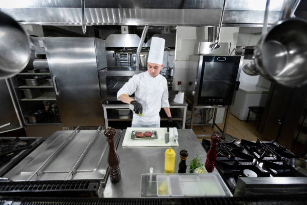 istock A chef in a white uniform and a cap marinates meat, pours oil in a professional kitchen 1646366296