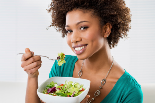 Close-up Of Beautiful African American Woman Eating Salad At Home.