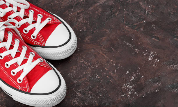 istock Red sneakers on dark background with copy space. Youth shoes. 1646378191