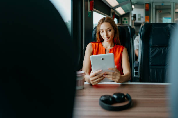 istock Woman multitasking with a digital tablet on the train 1646378197