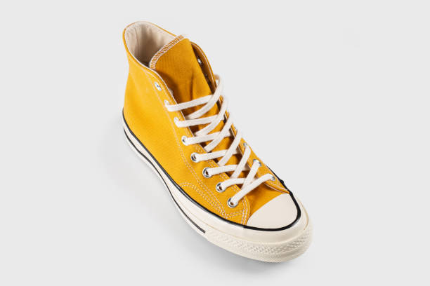 istock Yellow sneakers on white background with copy space. Youth shoes. 1646378764