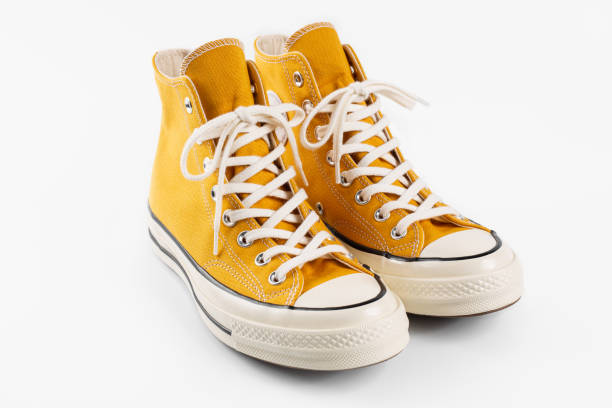 istock Yellow sneakers on white background with copy space. Youth shoes. 1646378792