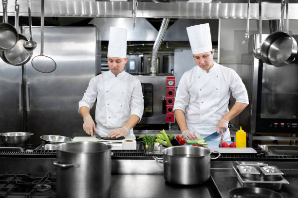 istock Restaurant Busy Kitchen, Chefs and Cooks Working on their Dishes. 1646384280