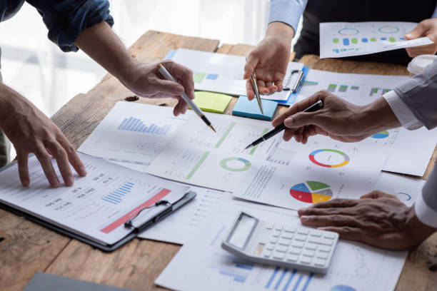 istock Financial analysts analyze business financial reports on a digital tablet planning investment project during a discussion at a meeting of corporate showing the results of their successful teamwork. 1646384323