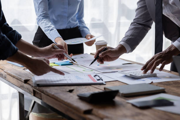 istock Financial analysts analyze business financial reports on a digital tablet planning investment project during a discussion at a meeting of corporate showing the results of their successful teamwork. 1646384828