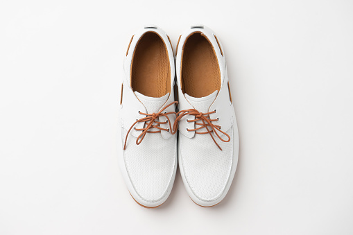 Casual white summer leather lace-up shoes. New men's soft loafers on a white background.