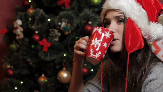 Woman in santa's hat drinking some beverage
